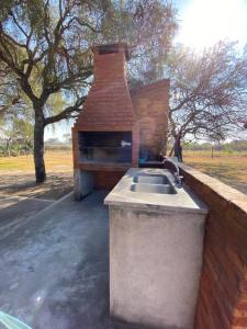 a outdoor kitchen with a sink and a brick oven at Casa del lago in Termas de Río Hondo