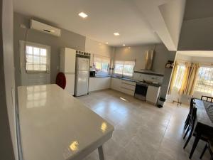 a large kitchen with a table and a refrigerator at Casa del lago in Termas de Río Hondo