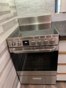 a stainless steel stove top oven in a kitchen at Ski-in, ski-out chaleureux studio loft au pied des pistes de ski in Stoneham