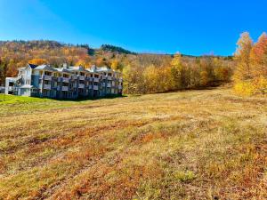 um grande edifício no meio de um campo em Ski-in, ski-out chaleureux studio loft au pied des pistes de ski em Stoneham