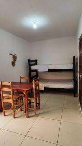 um quarto com uma mesa e cadeiras e uma cama em Chalés Residência Tatiane em Canoa Quebrada
