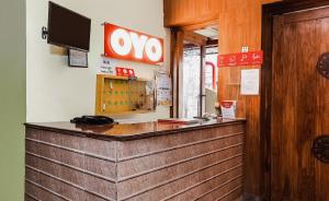 un comptoir de restaurant avec un signe woco sur le mur dans l'établissement OYO Sindhura Guest House, à Raspari Palao