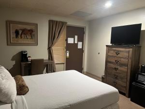 The Stables Inn & Suites في Salem: غرفة نوم بسرير وتلفزيون بشاشة مسطحة
