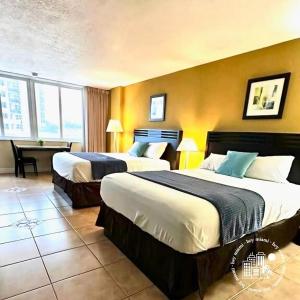 a hotel room with two beds and a table at Charming seaside studio for 4 people! - Rate included resort fee-Parking fee not included- in Sunny Isles Beach