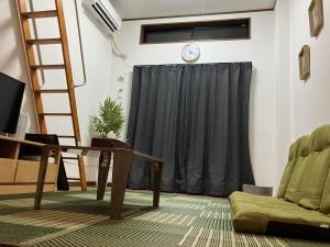 - un salon avec un rideau noir et une table dans l'établissement SAKURA Stay FUKUOKA2, à Fukuoka