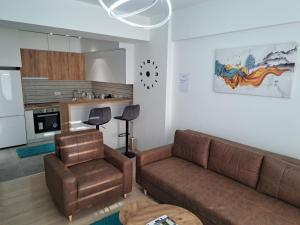 salon z kanapą i krzesłem w obiekcie Apartment Moki w mieście Skopje