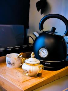 a tea kettle and a tea cup on a cutting board at Aix-en-Provence : le boudoir du centre historique in Aix-en-Provence