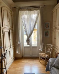a bedroom with a large window with a chair and a table at 2 pièces au centre de Monaco in Monte Carlo