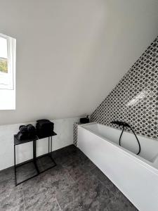ein Badezimmer mit einer Badewanne und einem Waschbecken in der Unterkunft Chalet Le René-Sens - 5 pers - Grande terrasse - bain nordique in Boutx