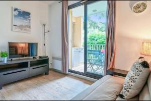 uma sala de estar com um sofá e uma grande janela em Joli T2 - domaine de la Coudouliere - Piscine em Six-Fours-les-Plages