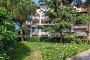 an apartment building with trees and flowers in front of it at Joli T2 - domaine de la Coudouliere - Piscine in Six-Fours-les-Plages