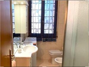 a bathroom with a sink and a toilet and a window at Appartamento Saragozza in Bologna +5 photos