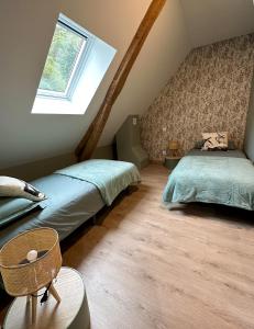 Schlafzimmer im Dachgeschoss mit 2 Betten und einem Fenster in der Unterkunft Chalet Le René-Sens - 5 pers - Grande terrasse - bain nordique in Boutx