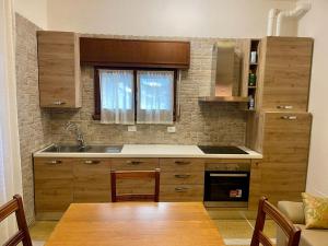 a kitchen with wooden cabinets and a table and a sink at Appartamento Saragozza in Bologna