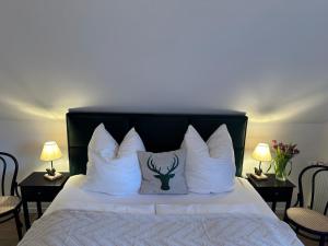 a bed with white pillows and a deer pillow on it at BergOase-Apart am Feldberg in Feldberg