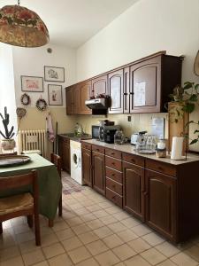 una cocina con armarios de madera y una mesa. en B&B Chiara, en San Sebastiano Curone