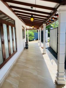 an empty hallway of a house with awning and columns at Villa Binna in Galle