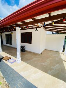 a covered patio with a red roof on a house at Villa Binna in Galle