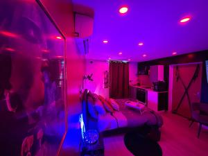 a bedroom with pink lights and a bed in a room at MJ Lust Room, centre var proche Verdon, cotignac, ambiance romantique in Montfort-sur-Argens