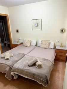 sypialnia z 2 łóżkami i ręcznikami w obiekcie Apartamento El Faro playa Nules w mieście Castellón de la Plana