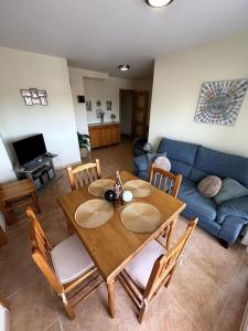 sala de estar con mesa de madera y sofá azul en Apartamento El Faro playa Nules en Castellón de la Plana