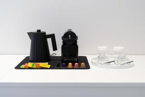 a black coffee maker on a counter with glasses at InSogno Suites in Naples