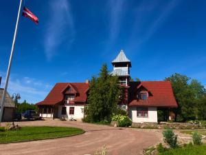 a house with a red roof with a tower at Pilskalni in Īvande