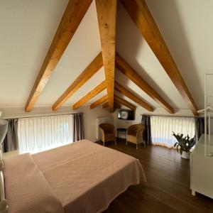 TaioAgritur La Pieve的一间卧室设有一张大床和木制天花板。 更多37张照片
