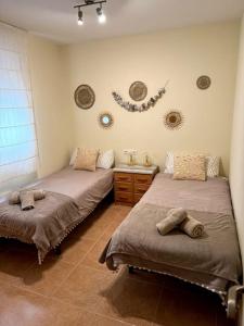a bedroom with two beds and a mirror on the wall at Apartamento El Faro playa Nules in Castellón de la Plana