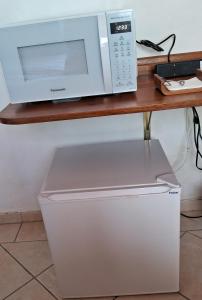 un horno microondas sentado en la parte superior de un mostrador en Sol poente, en Florianópolis