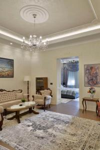 un soggiorno con divano e lampadario pendente di Zemun Center LUX 3 bedroom a Belgrado