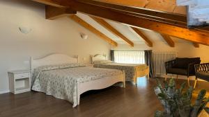 TaioAgritur La Pieve的有两张床和一把椅子的卧室