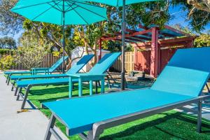 a row of blue picnic tables with umbrellas at Holiday Home 4 Bedrooms with Private Pool near HardRock Casino in Hollywood