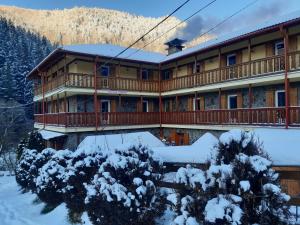 a large building with snow on the ground at Natura Tusnad in Băile Tuşnad