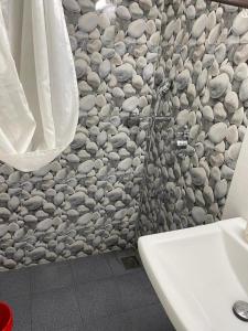 a bathroom with a stone wall with a sink at Tony's Inn Baga Apartment in Baga