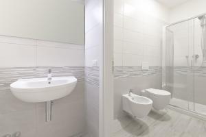 a white bathroom with a sink and a toilet at LHE Les Trois Merveilles - Grey Lewis in Cesena