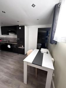 Una mesa blanca en una habitación con cocina en logement pour séjourner en Aix-en-Provence