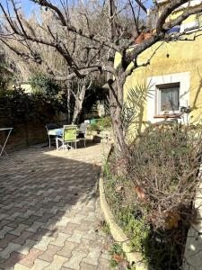 una casa con un árbol, una mesa y sillas en logement pour séjourner en Aix-en-Provence