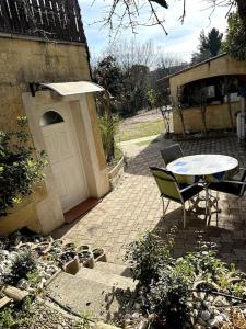 un patio con una mesa y una puerta blanca en logement pour séjourner en Aix-en-Provence