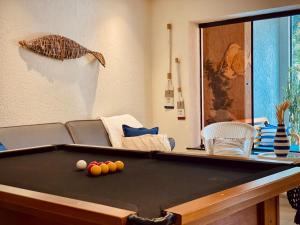 uma sala de estar com uma mesa de bilhar e um sofá em Porto Forte Pousada em Cabo Frio