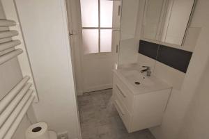 baño blanco con lavabo y ventana en Terracotta Studio en Orléans