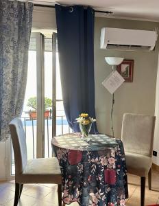 una stanza con un tavolo, due sedie e una finestra di Maison Romantique a Napoli