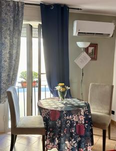 ナポリにあるThe Romantic Houseのテーブルと椅子2脚、窓が備わる客室です。