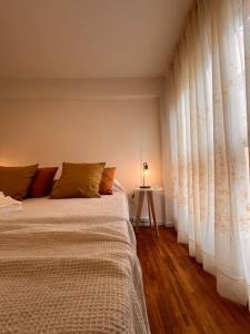 1 dormitorio con 1 cama con cortinas blancas y mesa en erental.arg departamento centro en Córdoba