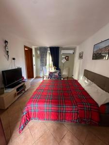 una camera con letto rosso e TV a schermo piatto di Maison Romantique a Napoli