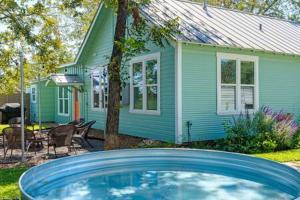 フレデリックスバーグにあるHello Bungalow - Hot Tub Fire Pit 1 BLK to Mainの緑の家とその前に青い車