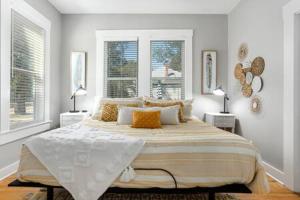 フレデリックスバーグにあるHello Bungalow - Hot Tub Fire Pit 1 BLK to Mainの白いベッドルーム(大型ベッド1台、窓2つ付)