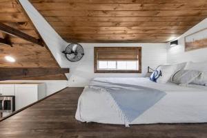a bedroom with a large bed with a clock on the wall at Life's a Beach - 3 Acres with Hot Tub in Fredericksburg