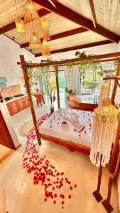 um quarto com uma cama coberta de pétalas de rosa vermelhas em BANGATACHO - Bangalôs Temáticos na Praia do Patacho - Milagres em Porto de Pedras