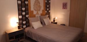 um quarto com uma cama grande com lençóis brancos e almofadas em Le bois de laval em Fussey